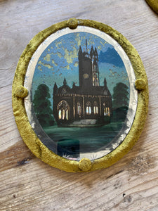 Pair of reverse painted glass framed churches